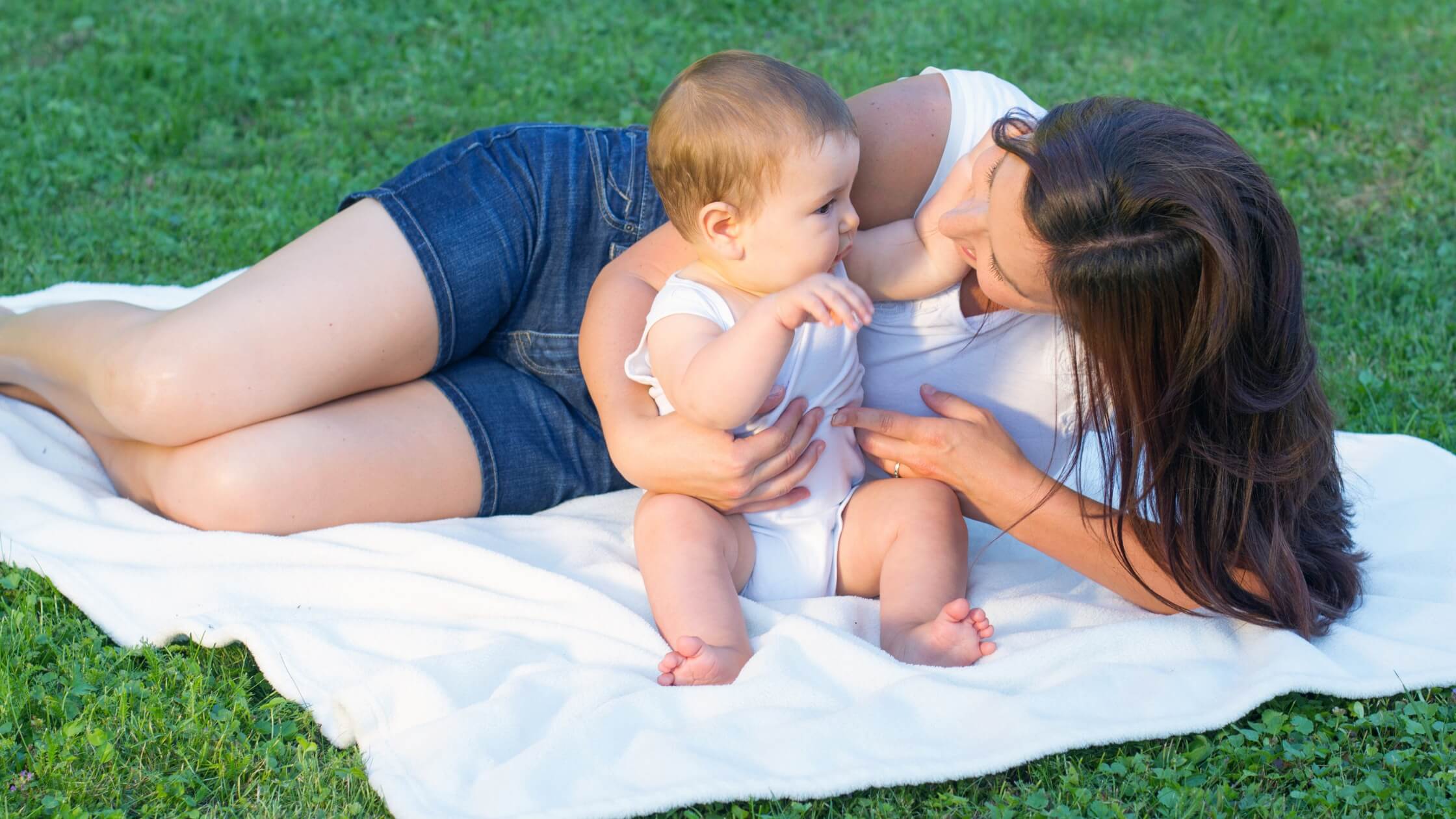 mom and baby playing on blanket outside