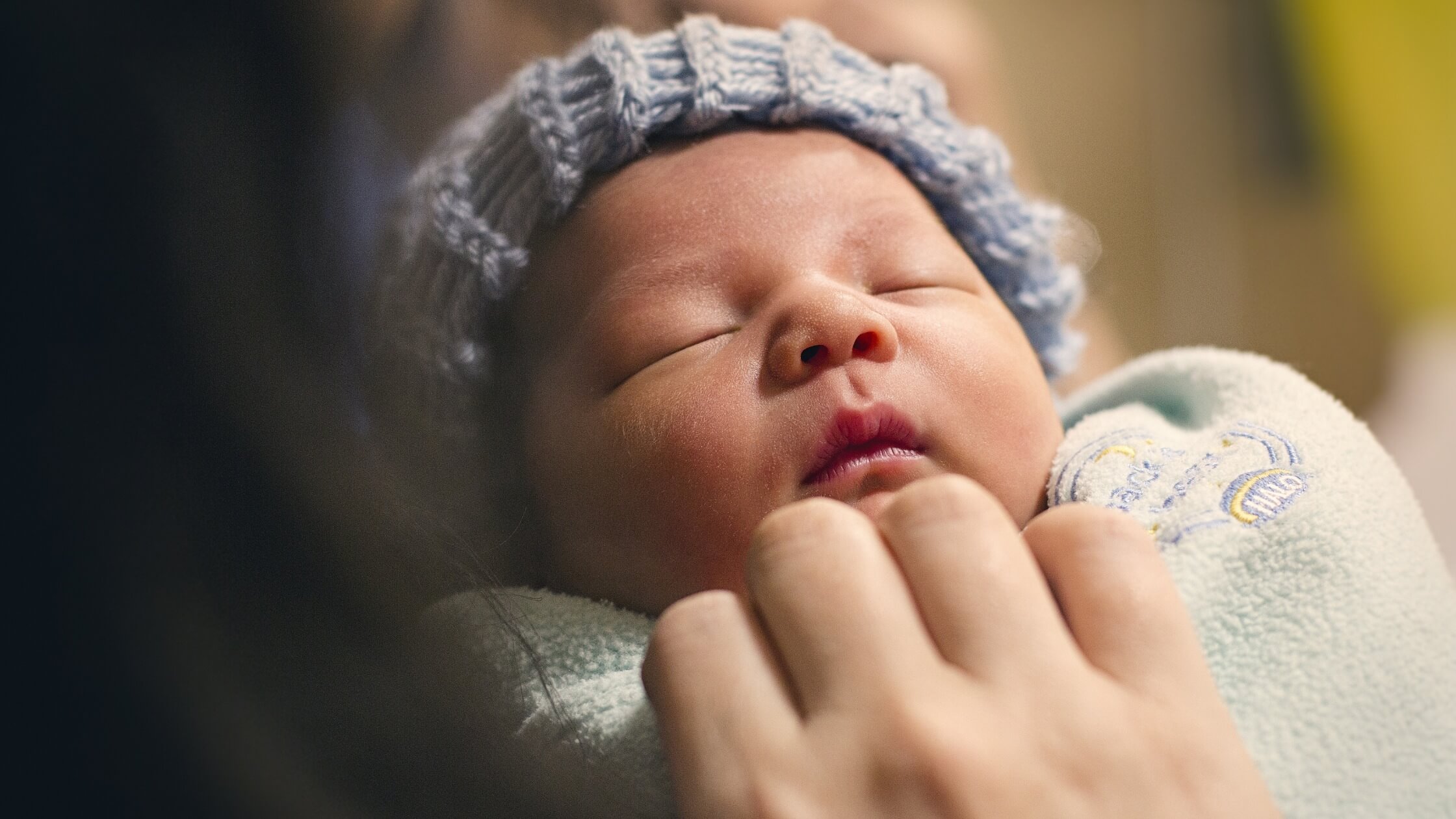 baby sleeping in mom's arms