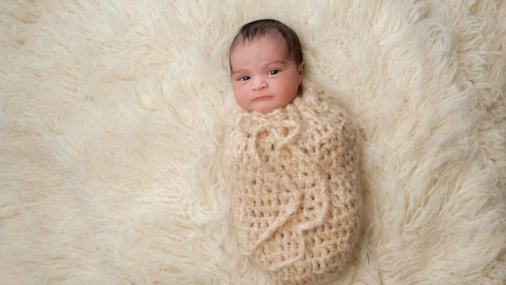 baby swaddled in crib