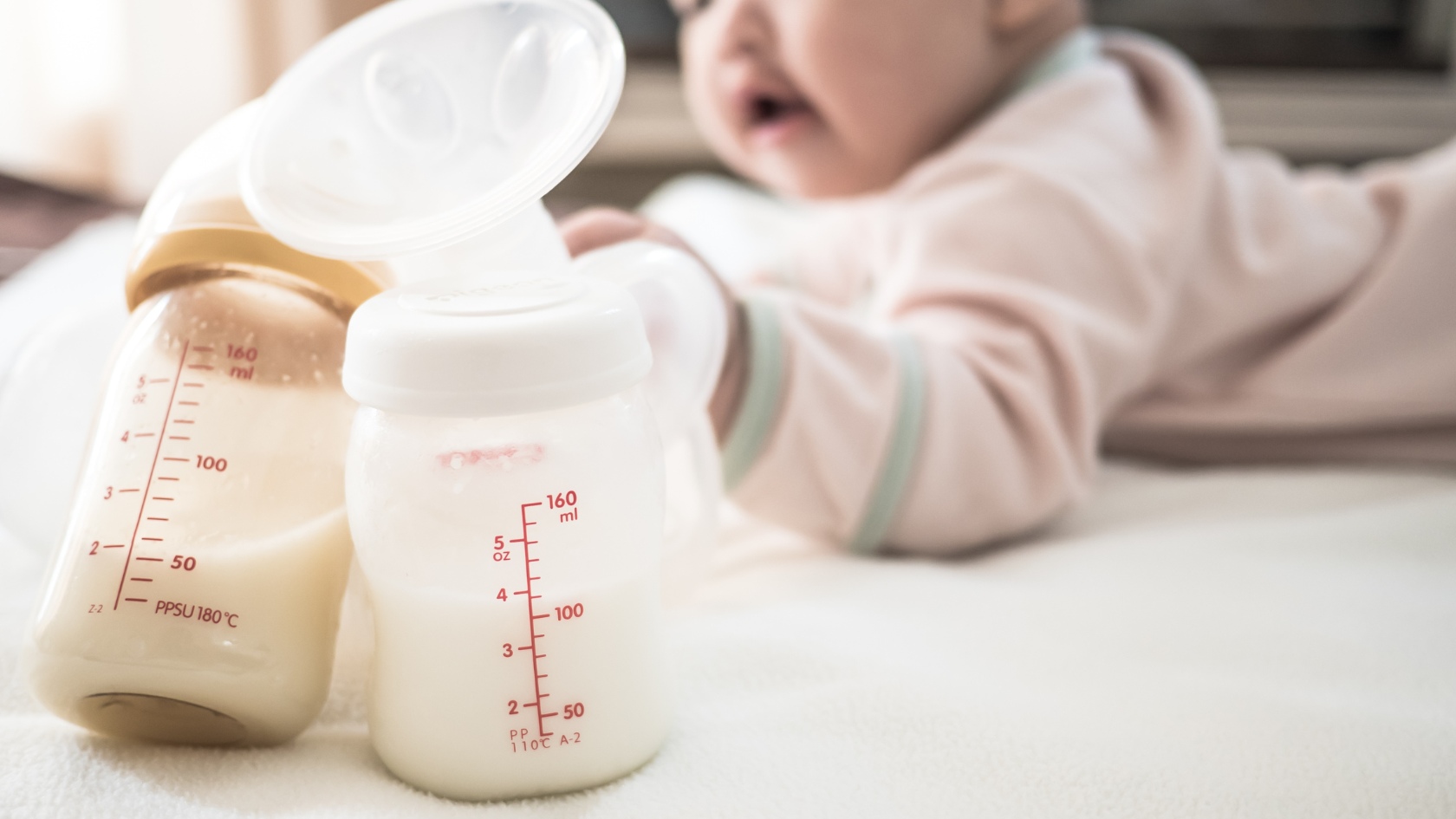 baby reaching for bottles of milk