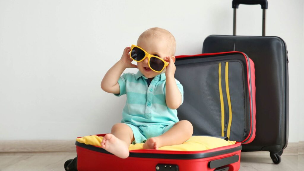 baby on suitcase wearing sunglasses ready for travel