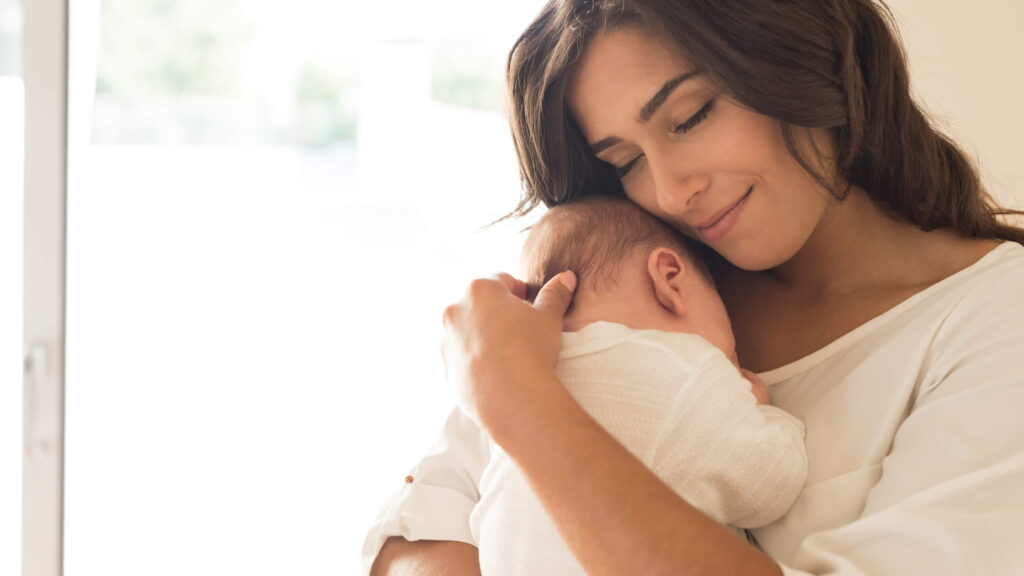 mom holding a sleeping baby