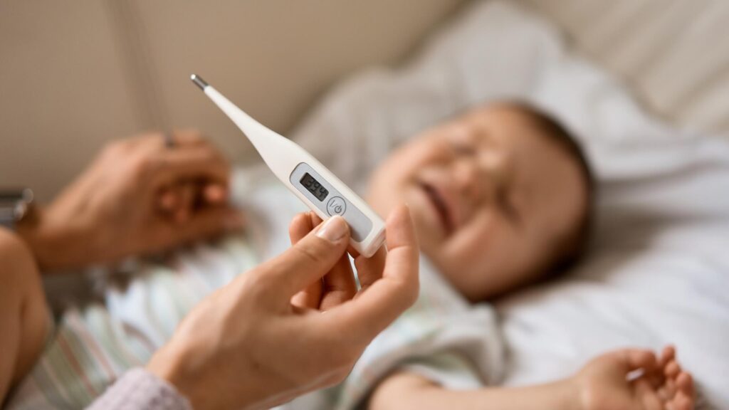 baby with cold mom taking temperature