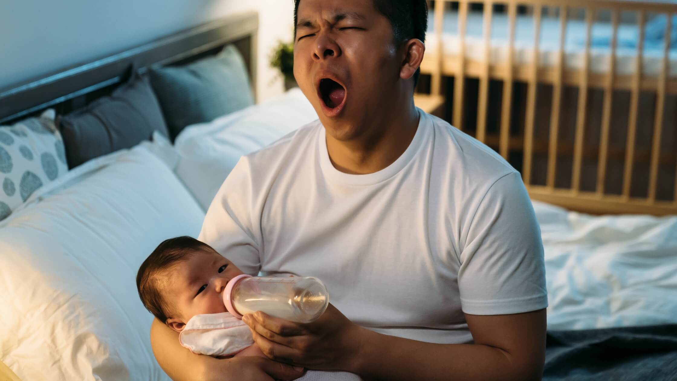 father holding baby at night feeding